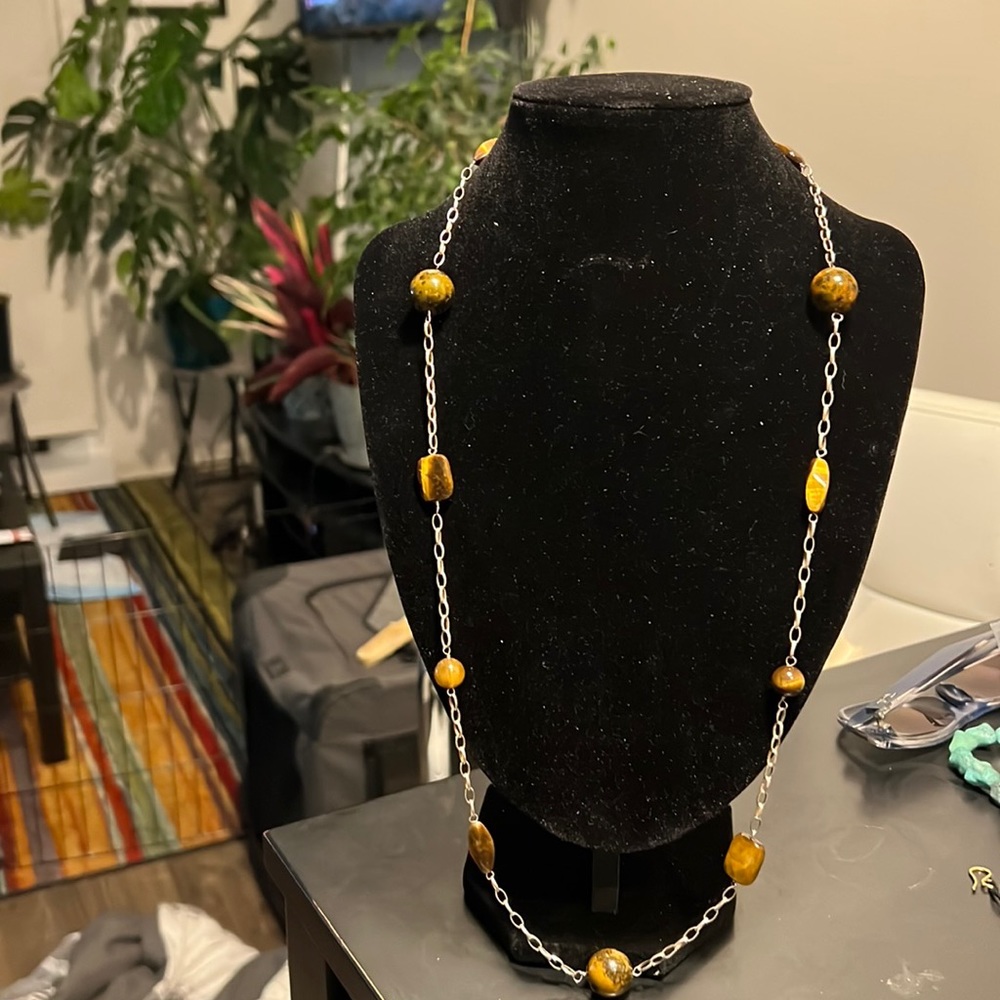 14 inch silver necklace with 12 tiger eye stones. There is no clasp